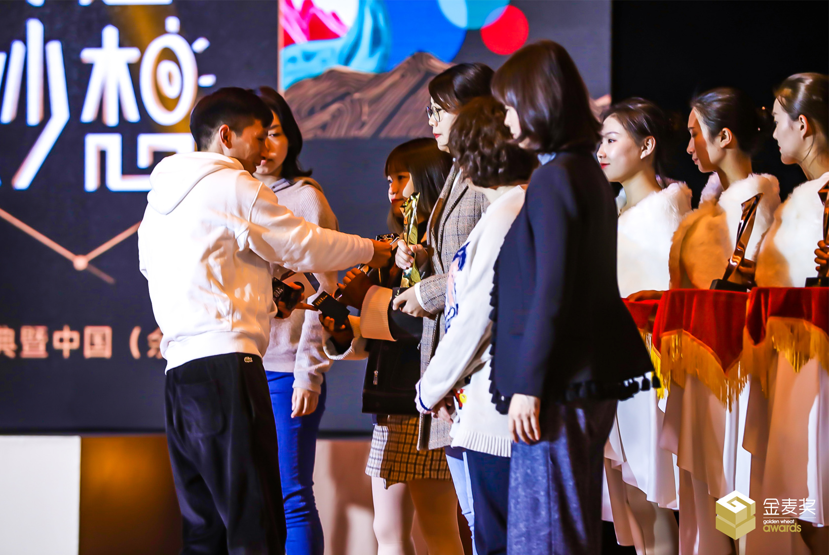 嘉賓和禮儀小姐上臺(tái)為金麥獎(jiǎng)獲獎(jiǎng)?wù)哳C發(fā)榮譽(yù)